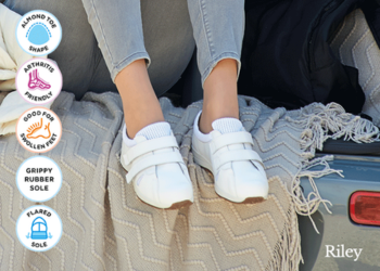 A woman wearing a pair of white trainers on a rug