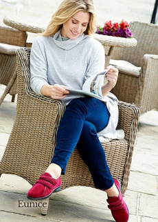 Women sitting on chair reading with red slippers