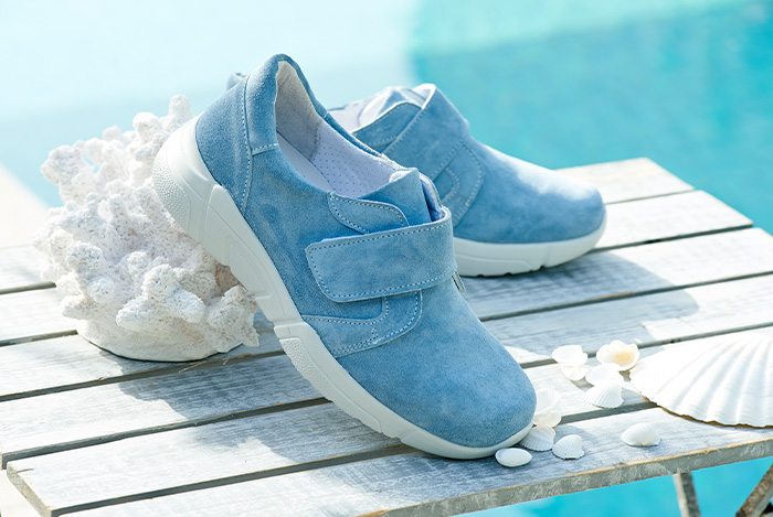 A pair of blue strap trainers next to a pool