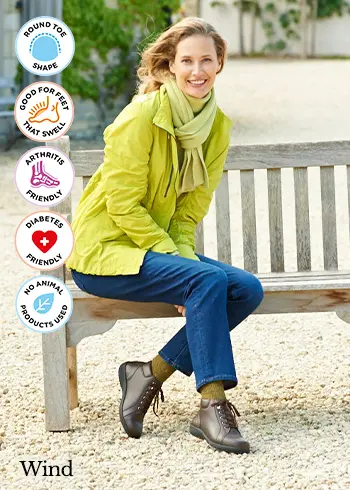 A woman sat on a bench wearing brown boots
