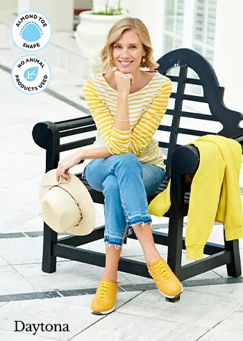 A woman sat on a bench wearing yellow trainers