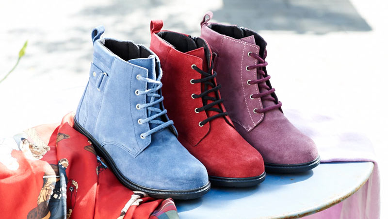 3 different coloured boots on a table
