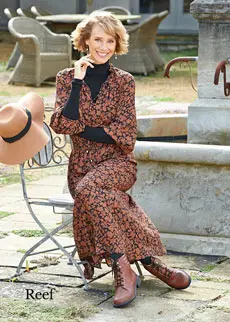 Woman wearing brown boots and dress sitting