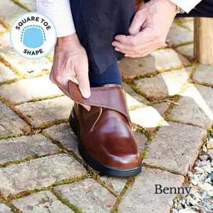A man strapping up a brown shoe