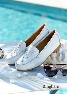 A pair of white loafers next to a pool