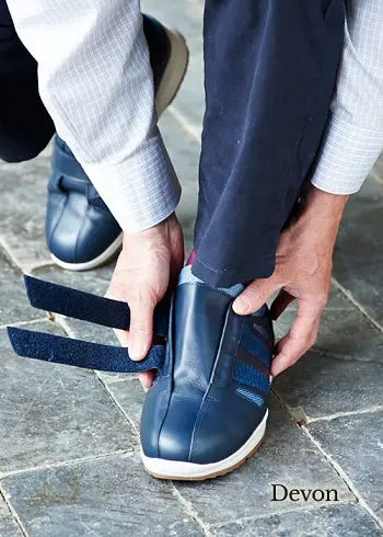 A man adjusting a strap on blue shoe