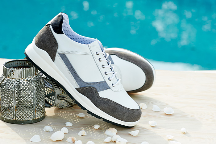A pair of white trainers next to a pool