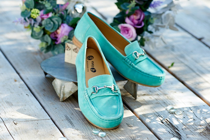 A pair of green loafers on decking