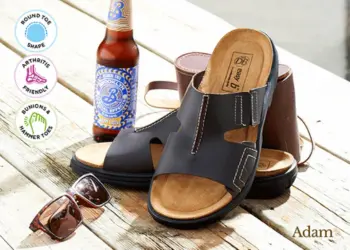 A pair of brown sandals next to a bottle of lager