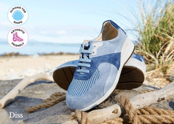 A pair of blue trainers on a beach