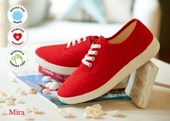 A pair of red canvas shoes on a table