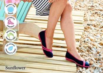 A woman wearing a pair of black shoes on a beach