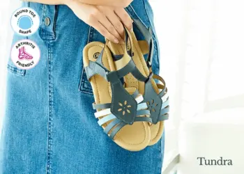 A woman carrying a pair of strappy sandals