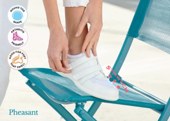 A woman putting on a pair of white strap shoes