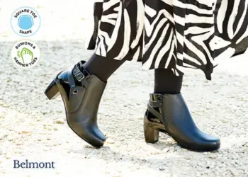 A woman in a black and white dress wearing black boots