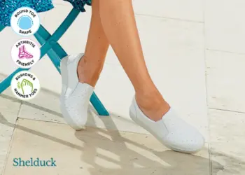 A woman sat in a blue dress wearing white shoes