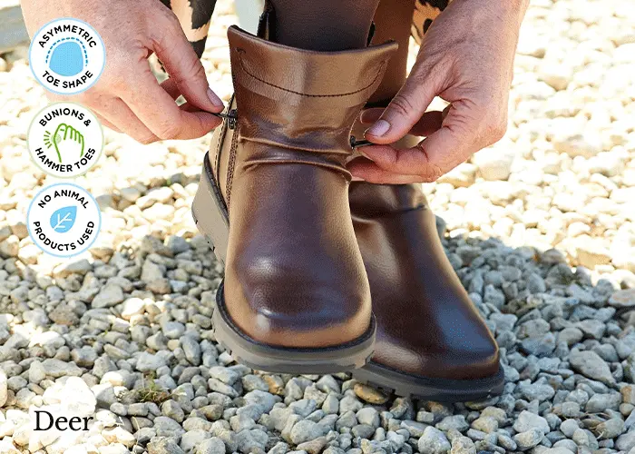 A woman putting on a pair of brown boots