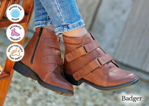 A woman wearing a pair of brown strap boots