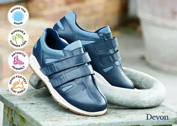 A pair of men's blue strap trainers on a table