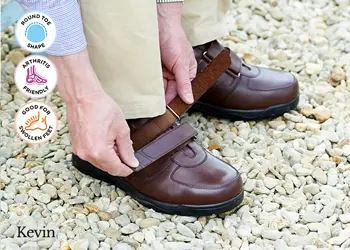 A man strapping up his brown shoes