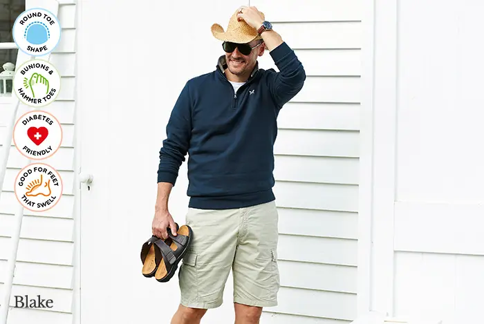 A man carrying a pair of brown sandals