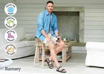 A man sat down wearing sandals