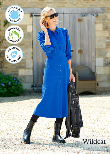 a woman in a blue dress wearing black boots