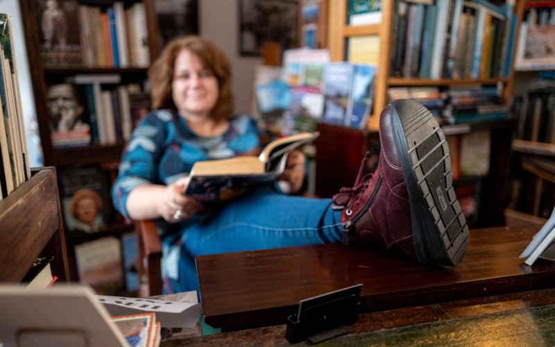 A woman sat in a chair with her feet up in a book shop