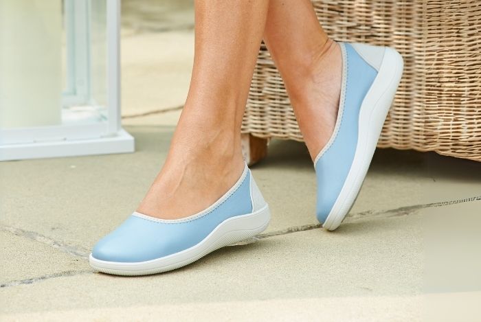 A person wearing a pair of light blue pumps