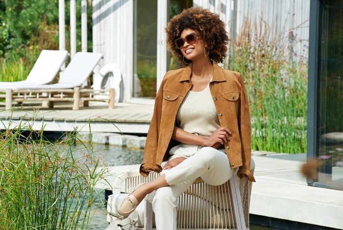 A woman sat on a chair outside next to some water