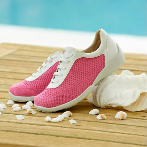 A pair of pink trainers by a pool