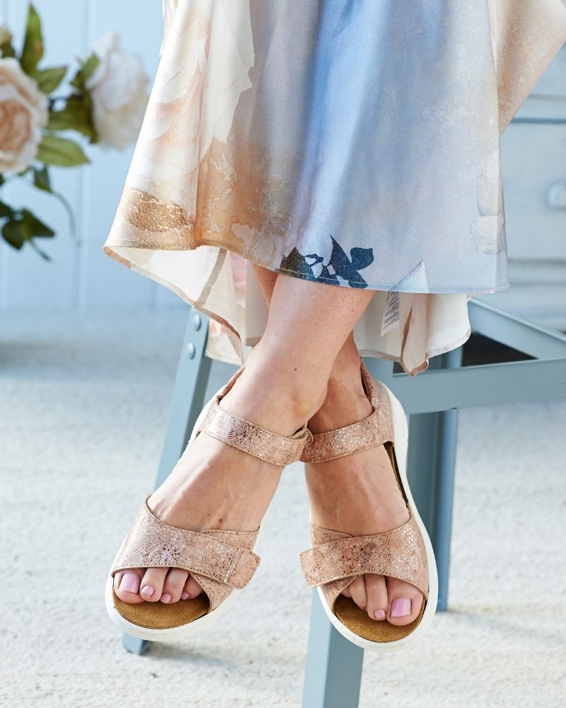 Someone sat on a chair wearing a blue dress and sandals