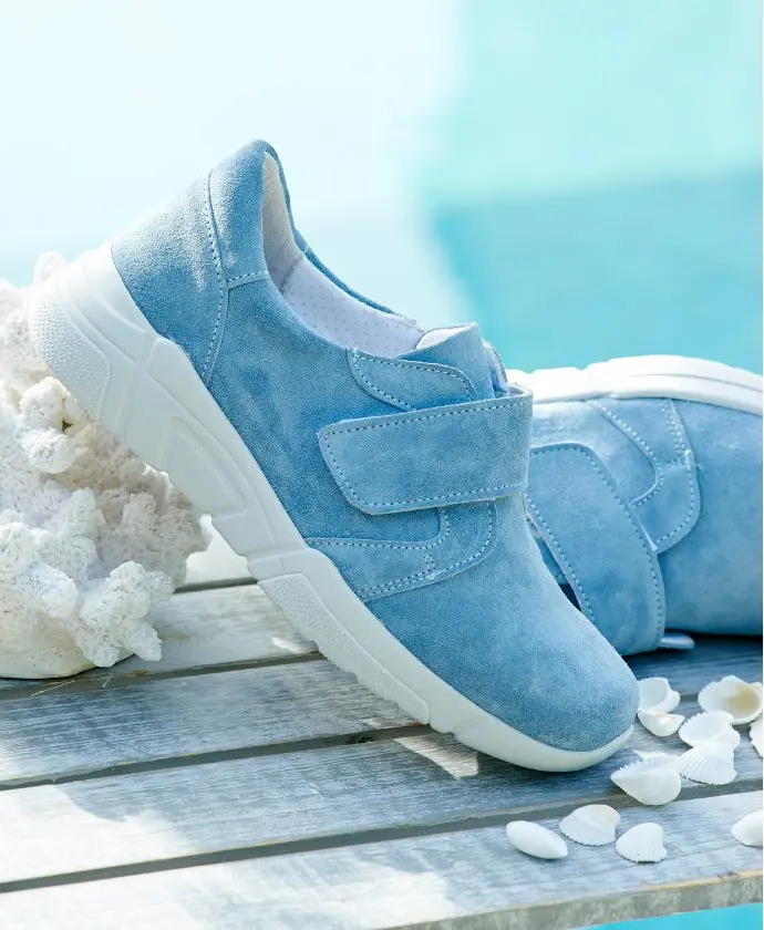 A pair of blue strap trainers on a table