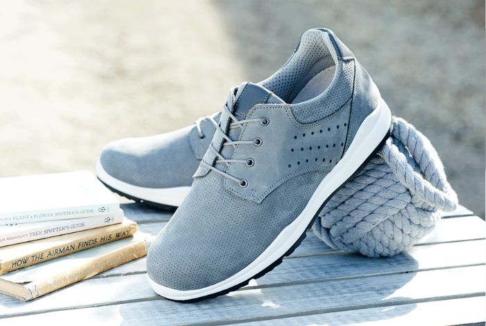 A pair of light blue trainers on a wooden table