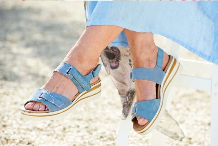 Someone sat wearing a pair of blue sandals