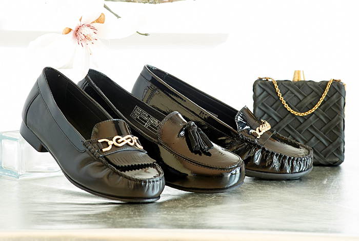 A trio of different black loafers on a table