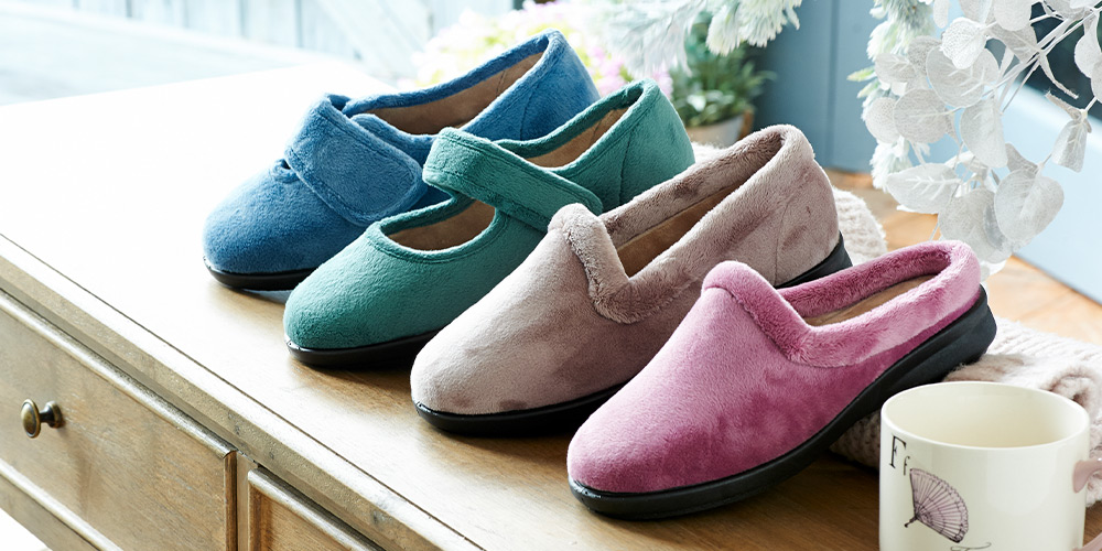 4 different colour slippers of the same style on a side draw